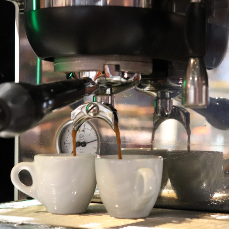 Kuva espressokoneesta, josta valuu kahvia kahteen kahvikuppiin.